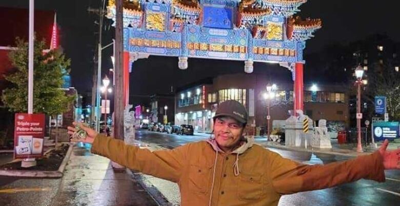 man in front of chinatown gate