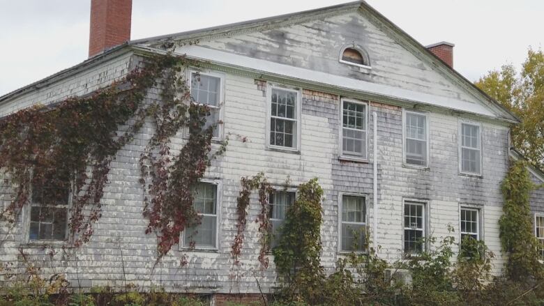 The backside of the house shows peeling paint