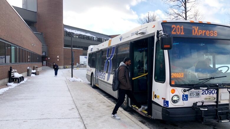 A man walking into a public transit bus.