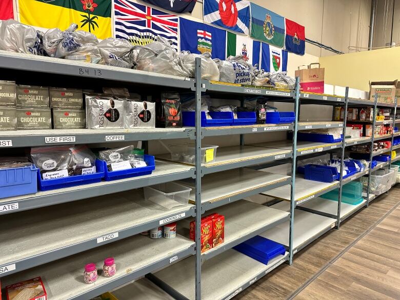 Low food stock is visible on the shelves at the Veterans Association Food Bank