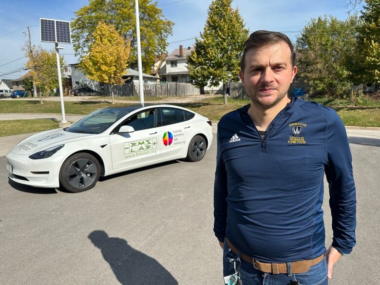 Francesco Biondi is an associate professor of kinesiology at the Human Kinetics faculty at the University of Windsor. He stands in front of the Tesla car he used in his driver attentiveness study.