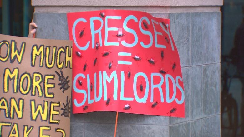 A sign reads 'Cressey = Slumlords', with stuck on bugs.