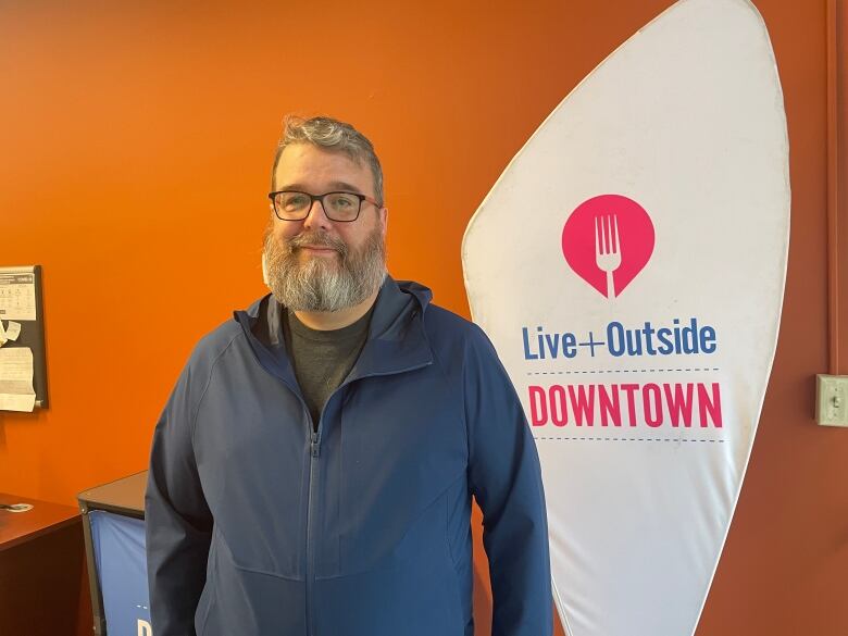 A man with a beard wearing a blue sweater.