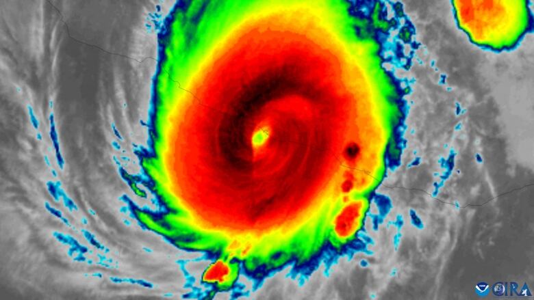 A satellite infrared image shows Hurricane Otis making landfall in Mexico, with heavy bands of rain shown in red.