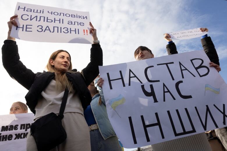 People hold placards during a protest calling for legislation regulating the length of active military duty.