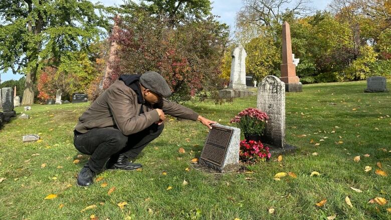 Man crouches to touch plaque