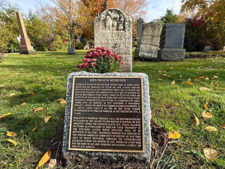 Plaque in front of tombstone