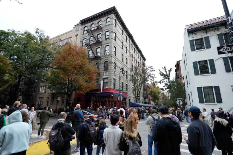 People gather outside of a building in New York City that was used in exterior shots of the television show Friends.