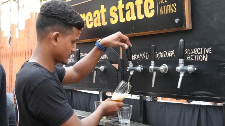 A bartender pulls a pint of beer made from the sugar extracted from millets at a bar in Mumbai, India.