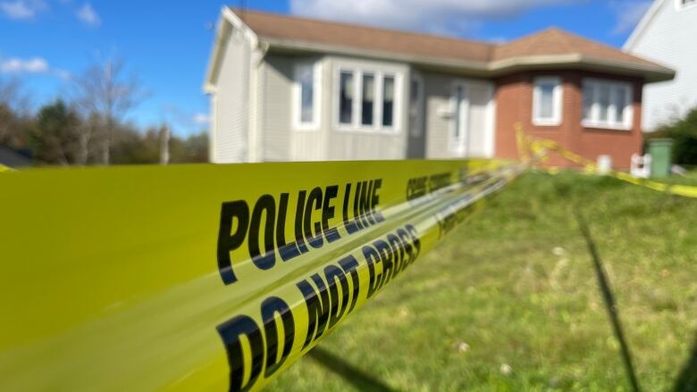 Police tape reading 'police line' in front of a house. 