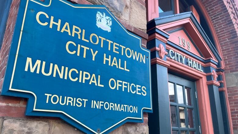 A brick building with a sign on the city that reads 'Charlottetown City Hall Municipal Services.'