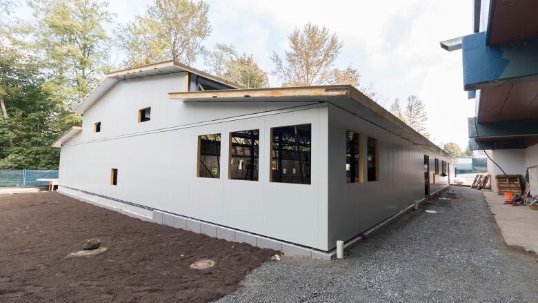 A small building under construction in a school yard. 