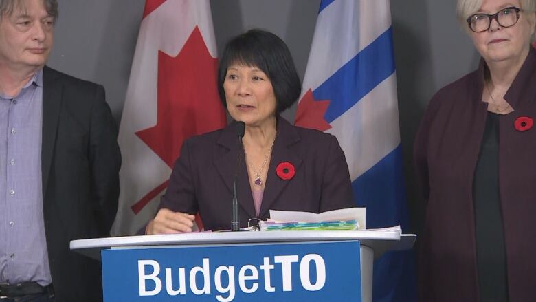 Mayor Olivia Chow stands at  podium at city hall that says Budget TO