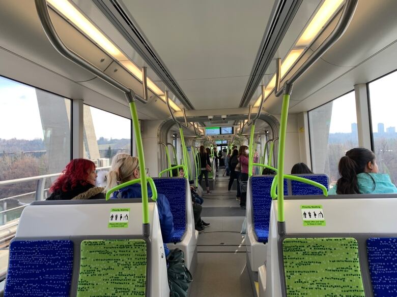 People sitting on a LRT train with their backs to the camera