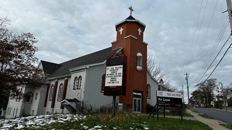 A white Catholic church with a brick steeple.