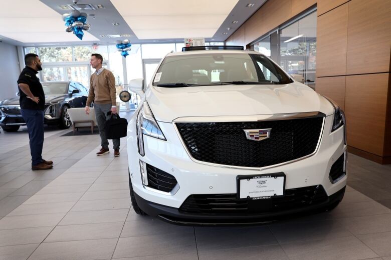 Two men in a car dealership.