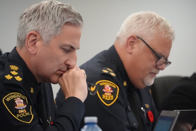 Two men sits at a table in police uniforms