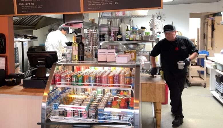 A middle-aged man walking from one end of his kitchen diner to the other at Okanagan Street Food in Kelowna, B.C. 