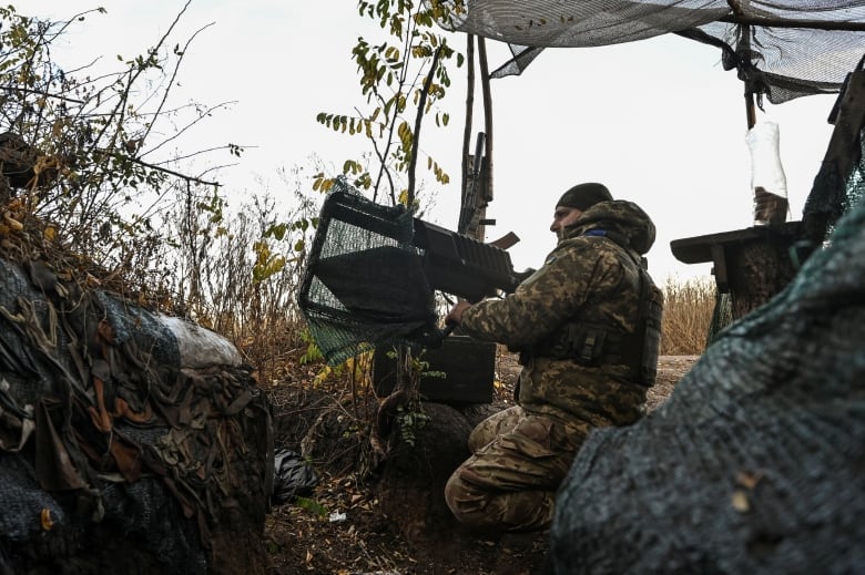 A Ukrainian soldier sits behind an anti-drone rifle in Ukraine's Zaporizhzhia region.