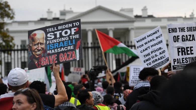 A protester holds up a sign that read, 'Tell Biden to stop funding the Israeli massacre; save Gaza,' as demonstrators gather in front of the White House.