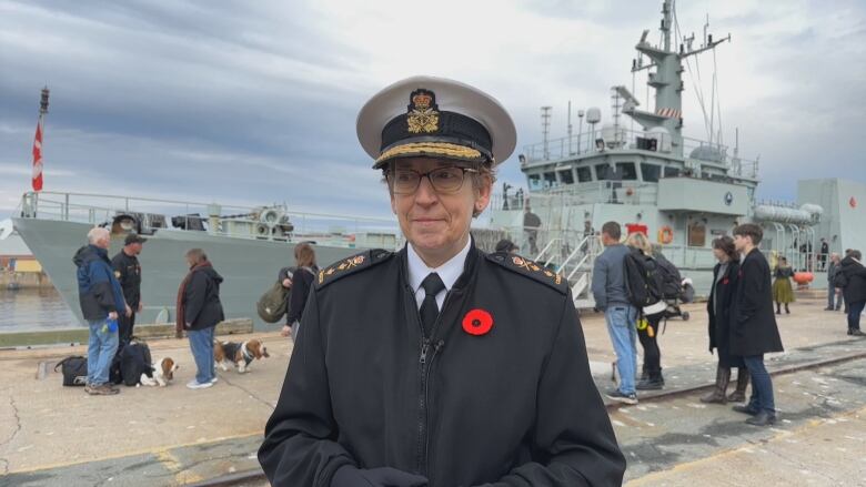 A woman in a rear admiral uniform speaks to the camera.