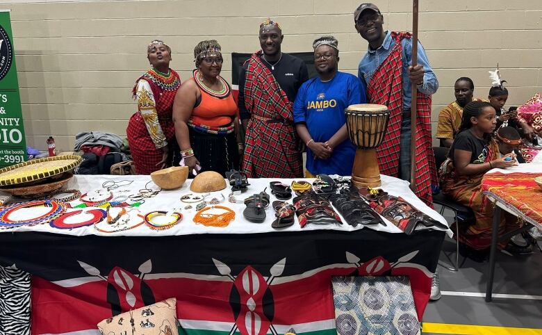 A group of five people stand behind a table full of artifacts.