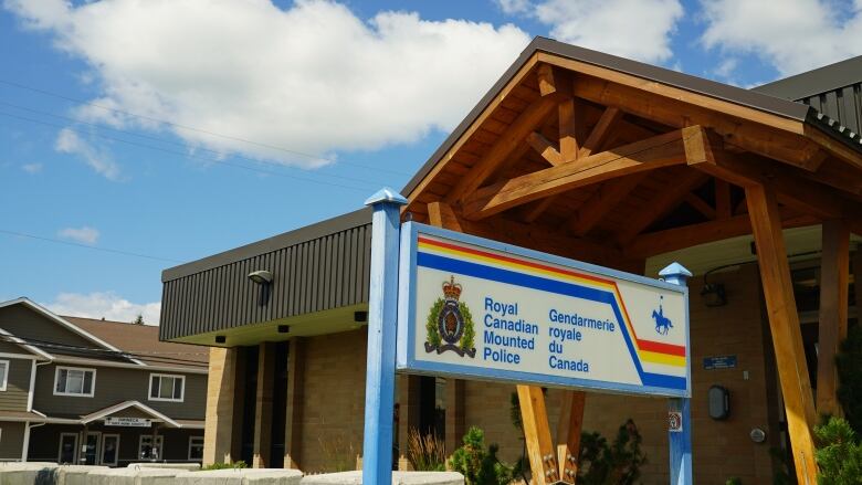 Wood beam building with RCMP detachment sign in front on a sunny day