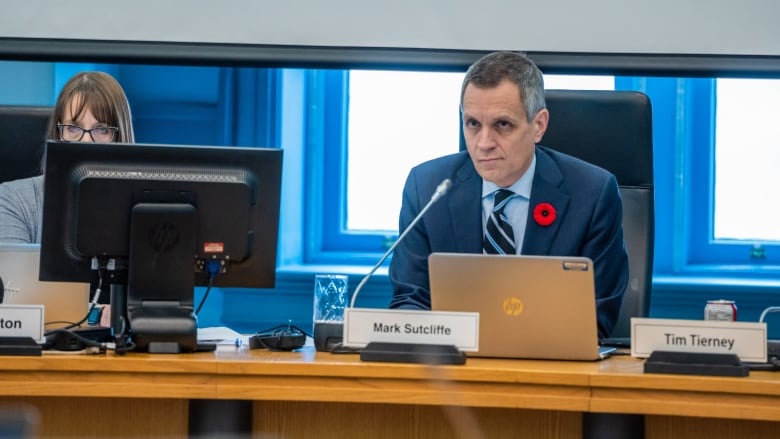 A man sits behind a microphone.