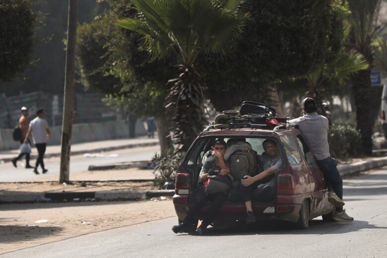 A group of Palestinians are seen fleeing the al-Rimal neighbourhood of central Gaza City, via car, on Wednesday.