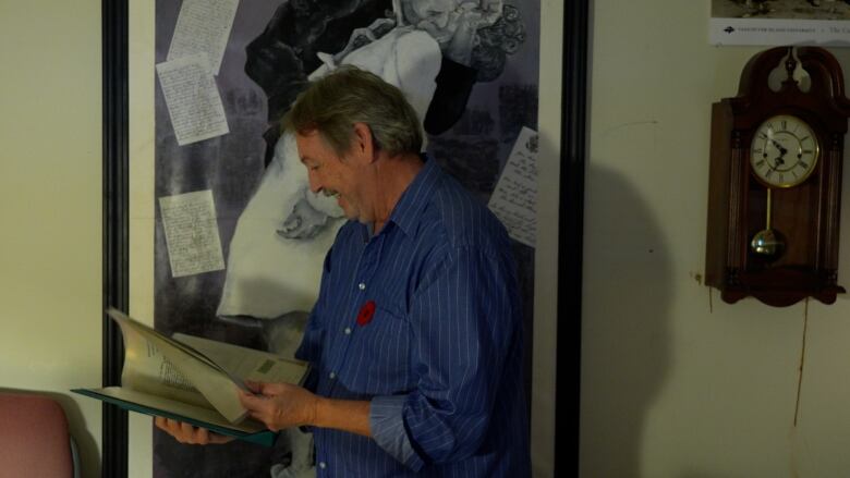 Dr. Stephen Davies browses a binder of letters and images from soldier's from the World Wars. 