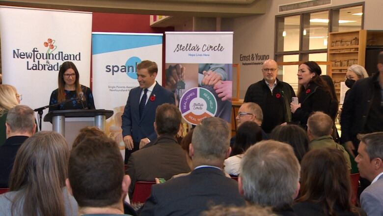 A room filled with people sitting on chairs in front of a podium. 