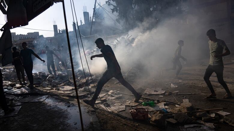 Palestinians look for survivors following an Israeli airstrike in Khan Younis refugee camp, southern Gaza Strip, Tuesday, Nov. 7, 2023.