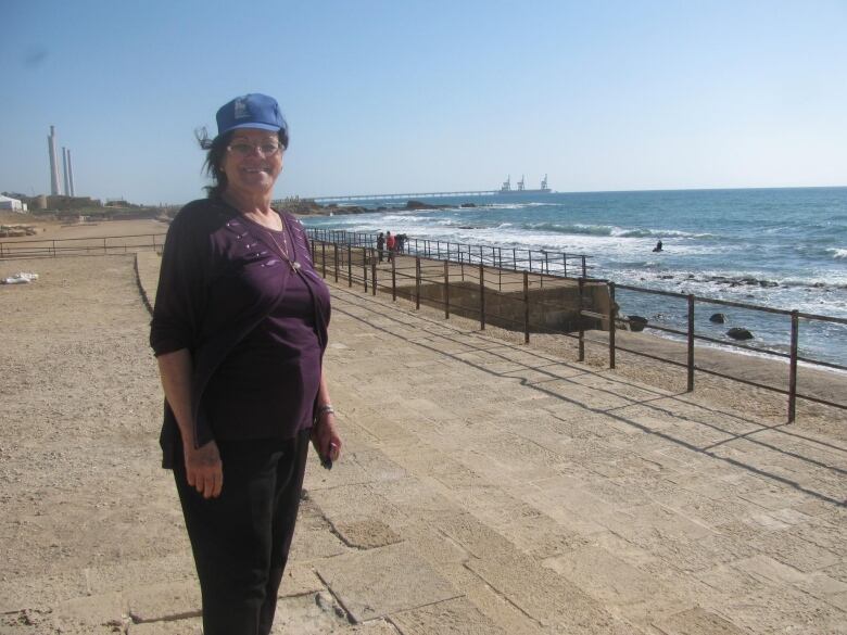 A woman smiles at the beach.