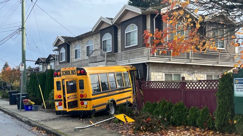 A yellow and black school bus crashed into a home.