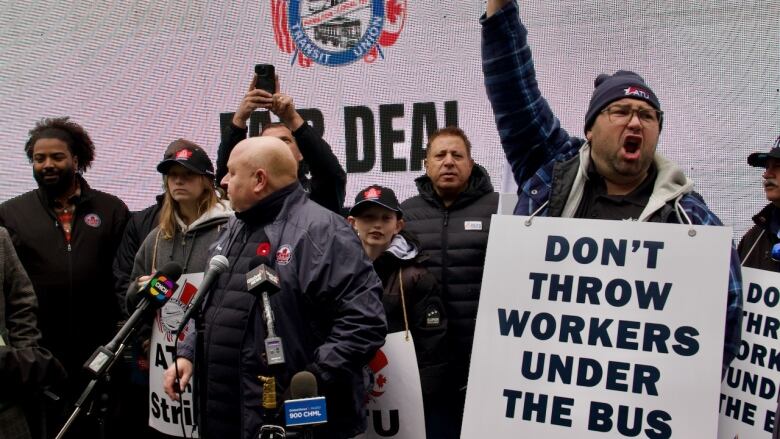 Strikers hold signs reading 