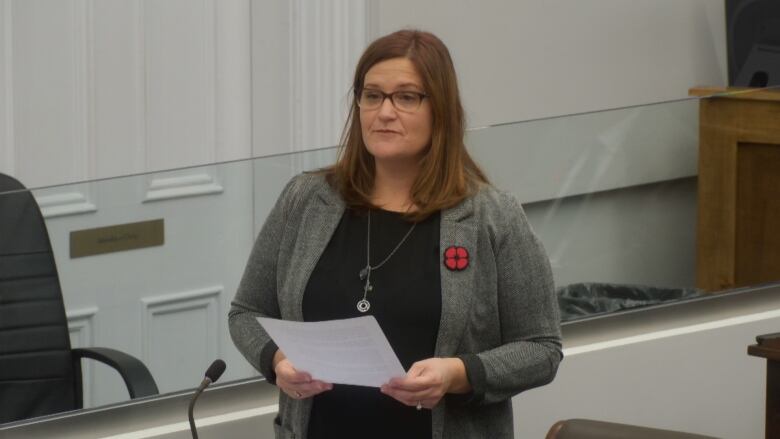 A woman in a grey suit and black shirt standing in the P.E.I. legislature.