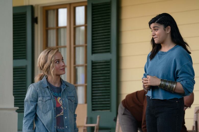 A woman looks at a teenager, who has a slightly worried look on her face. 