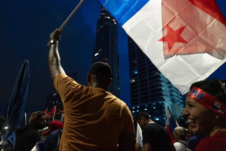 A protester waves Panamanian flags during a demonstration to celebrate the moratorium on new metal mining exploration, in Panama City, Panama