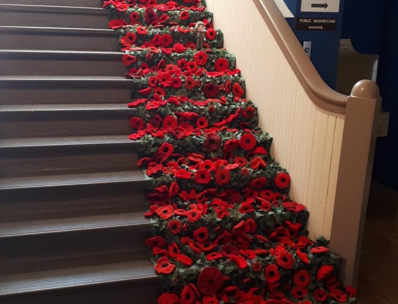 Poppies occupy half the width of a staircase. a small stuffed soldier is also visible. 