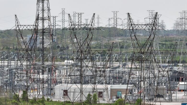 A cluster of tall high tension power lines and transformers.