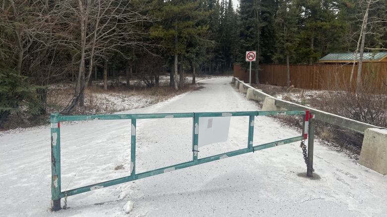 A closed gate on a snowy paved trail.