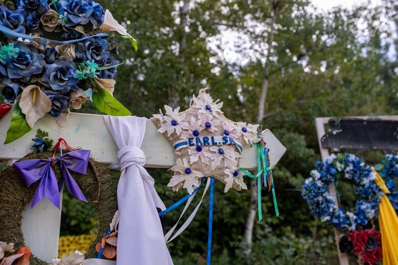 A memorial to Earl Burns has flowers and his name on it