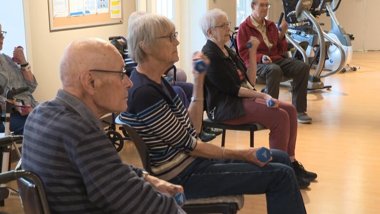 a group of seniors lifting weights in a circle