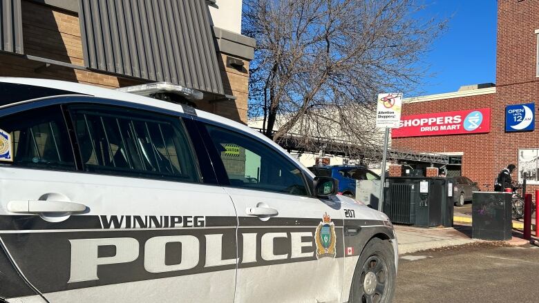 A police car sits on a street outside a building.