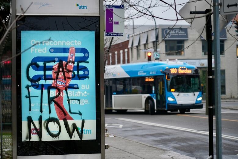 A bus stop in Montreal covered with graffiti that reads, ceasefire now. 