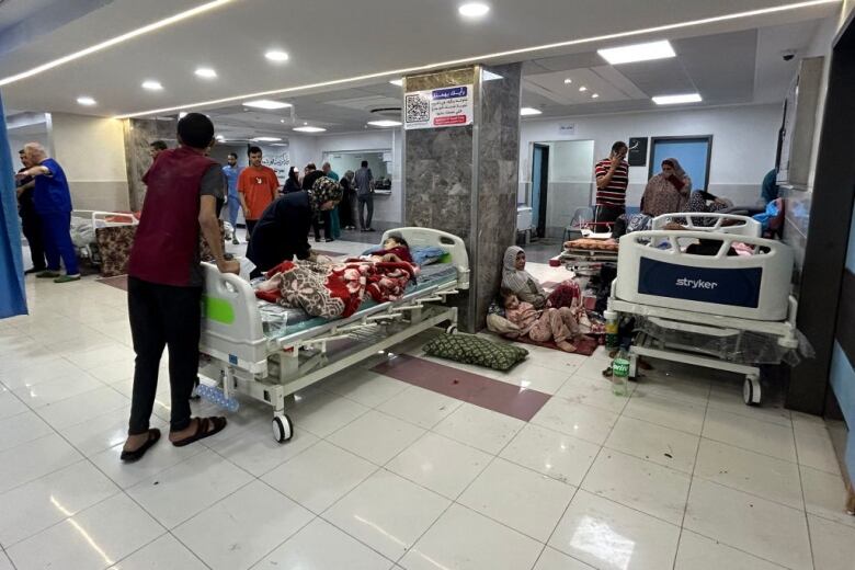 A crowded hospital with many patients on the floor in the emergency department.