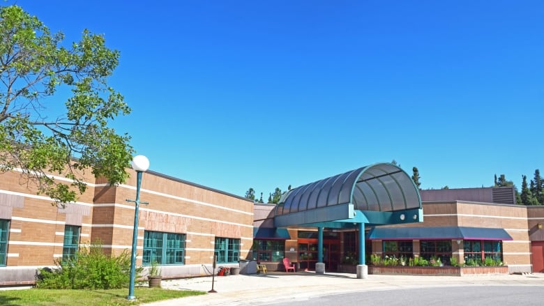 A reddish-brick building beneath a blue sky.