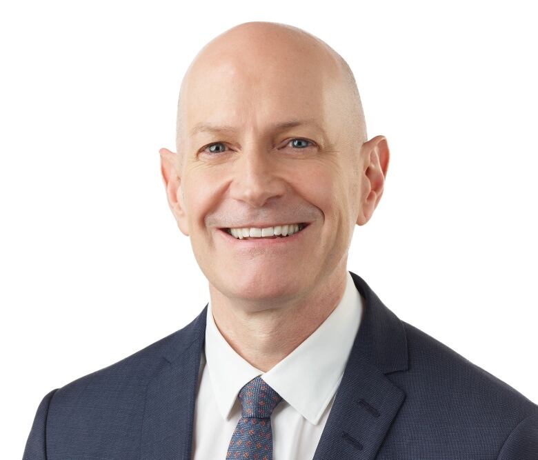 A man in a suit with a white background. 