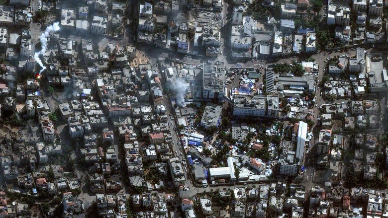 An aerial view shows a city with destroyed or damaged buildings.