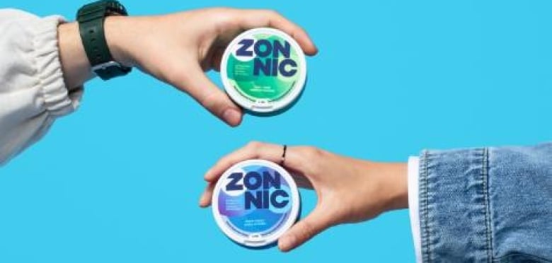 An ad for Zonnic shows three hands holding round, colourful packages over a bright blue background.